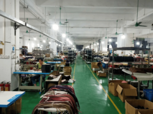 An industrial factory scene showing numerous employees actively working on production lines and equipment.