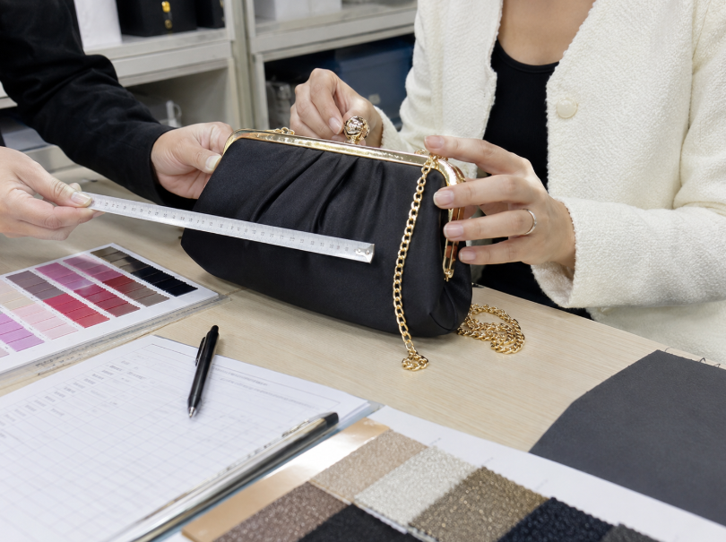 Inspecting A Custom Evening Bag Sample Before Bulk Production